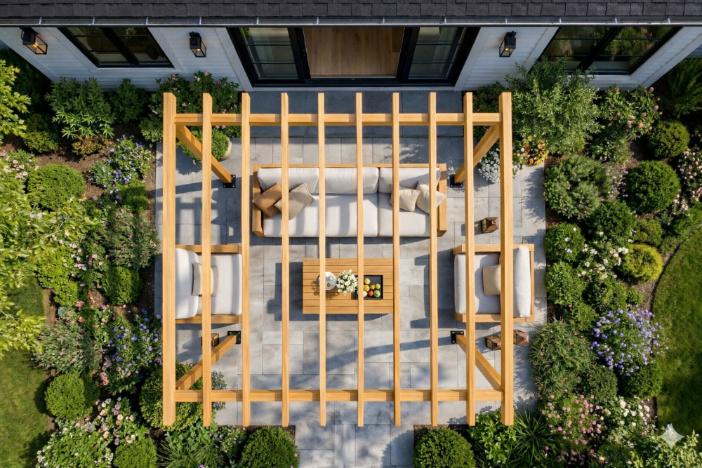 A wooden pergola structure in a garden setting with outdoor furniture.