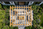 A wooden pergola structure in a garden setting with outdoor furniture.
