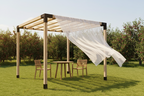Wooden pergola with a white canopy in a garden setting