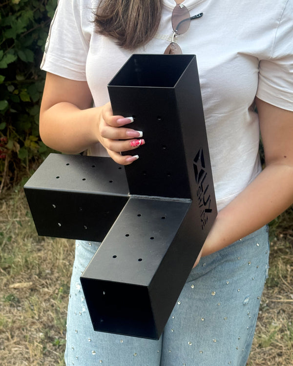 Person holding a black L-shaped product with LuxShade branding outdoors.