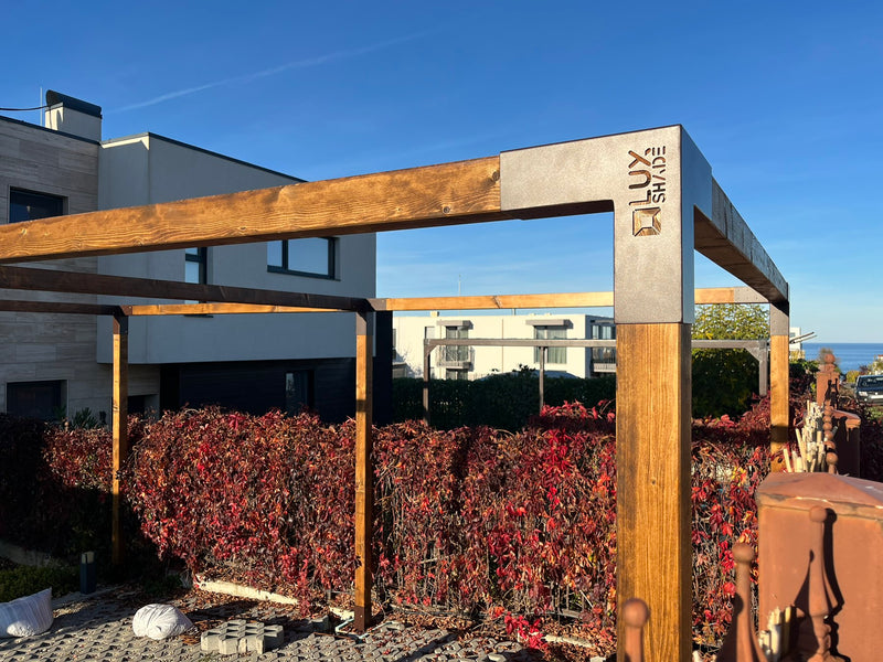 Wooden pergola with metal support structure in a garden setting
